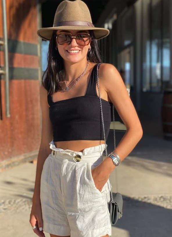 Wide-brim hat, black crop top, and cream linen shorts in daylight